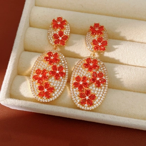 Detail of vintage flower drop earrings with red petals and zircon in a jewelry box