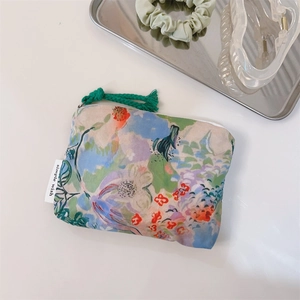 Detail of oil painting style cotton mini pouch with floral print and side logo tag