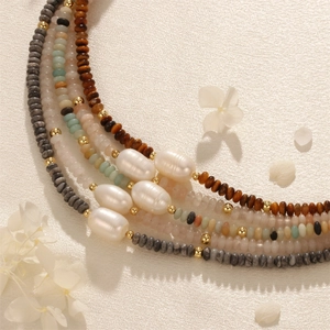 Macro view of bohemian necklace with tiger eye stones and baroque freshwater pearls