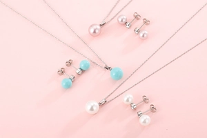 Flat lay of pearl jewelry sets in pink, blue, and white with sparkling rhinestones