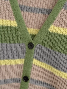 Detail of V-neck knitted cardigan with colorful stripes and textured button closure