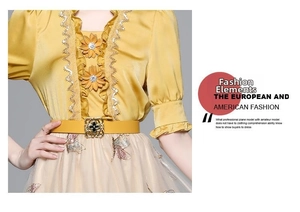 Detail of yellow satin top with 3D daisy flower and embroidered butterfly mesh skirt