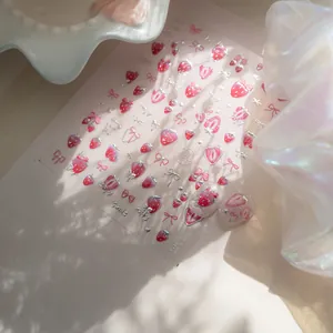 Detailed 3D embossed nail stickers featuring pink strawberries, bows, and heart patterns