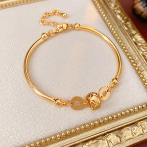 Detailed view of 18K gold-plated bamboo bracelet with quilted pattern spherical charm