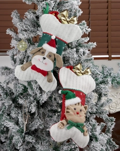 Bone-shaped Christmas stockings with cartoon pets hanging on a snowy Christmas tree