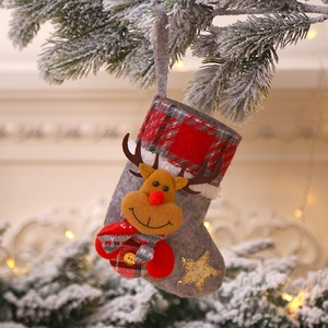 Detail of grey felt Christmas stocking with reindeer doll and red plaid cuff decor
