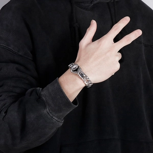 Close-up of a silver stainless steel Cuban chain bracelet with a boxing glove pendant