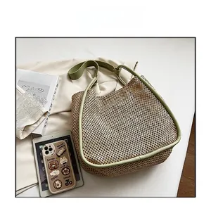 Macro shot of large straw tote bag with green leather trim and summer travel accessories