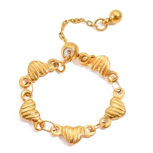 Detail of 18K gold heart chain ring with textured link surfaces and adjustable bead charm