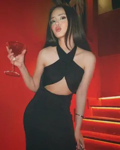 Detail of black halter cross-neck dress with cut-out waist design and slim fit cut