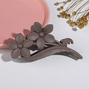 Detail shot of a matte brown flower hair claw with floral and leaf-vein design