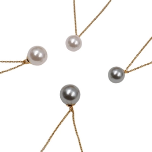 Collane minimaliste in oro 18 carats con perle tonde bianche e grigie su sfondo bianco