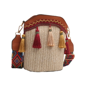 Detailed view of bohemian woven bucket bag with tassel charms and colorful wide strap