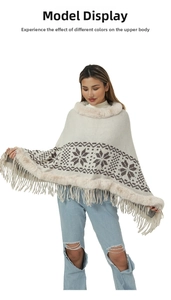 Detail of knit poncho featuring faux fox fur trim, tassel hem and snowflake jacquard