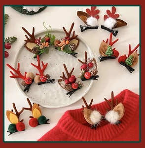 Detailed view of Christmas reindeer antler hair clips with pine cones and berries