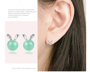 Close-up of rabbit earrings with green jade beads and silver zircon bunny ears