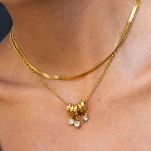 Layered 18K gold plated stainless steel necklaces featuring snake chain and crystal pendant