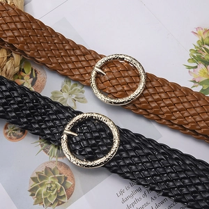 Brown and black woven PU leather belts with gold round buckles on a stylish background