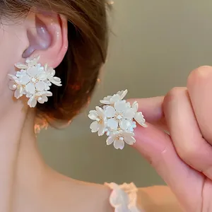 Elegant pearl flower cluster earrings with tassel details shown on a model for a chic look