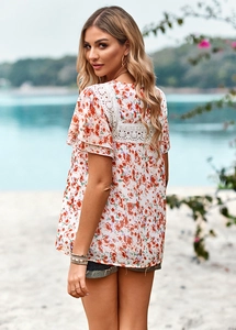 Detailed close-up of white floral summer top featuring delicate lace hollow back panel