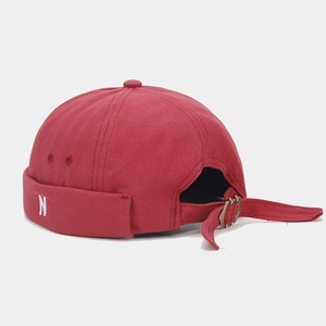 Detail of adjustable metal buckle and N embroidery on vintage canvas docker hat