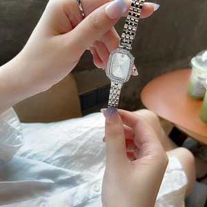 Makroaufnahme einer silbernen achteckigen Uhr mit Diamantlünette und Stahlarmband