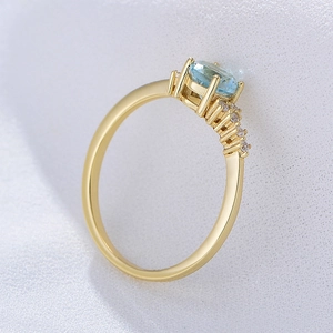 Elegant gold sterling silver ring with sky blue topaz and sparkling small side stones