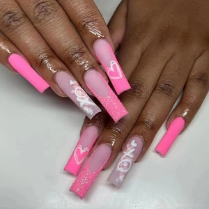 Detail of long ballerina press-on nails with rose pink glitter and white XOXO heart patterns