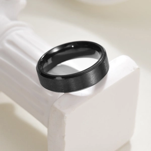 Minimalist black brushed titanium steel 6mm ring with polished inner surface on pedestal