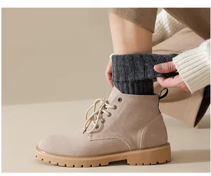 Close-up of beige suede work boots paired with thick dark grey thermal wool socks