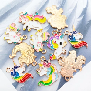 Detailed macro view of gold unicorn charms with colorful enamel for jewelry making