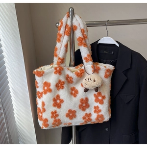 Detail of plush floral tote bag with lamb wool texture and cute animal pendant