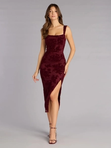Detailed texture of burgundy velvet fabric with floral patterns and high slit hemline
