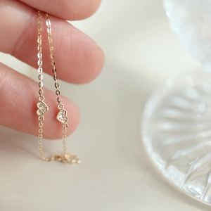 Macro view of gold heart chain bracelet with delicate cubic zirconia stone inlays