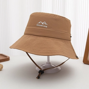 Detail of khaki outdoor bucket hat featuring mountain embroidery and windproof rope