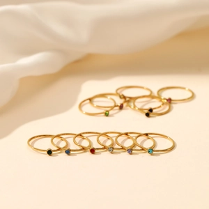 Minimalist stainless steel rings with colorful birthstones in a gold-finished slim band