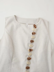 Detail of linen texture fabric with decorative faux tortoiseshell and white buttons