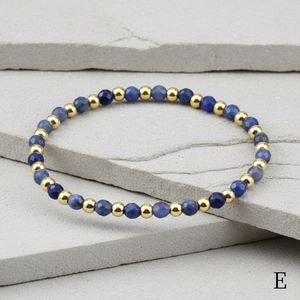 Detail of 4mm faceted Amazonite beads and gold metal spacers on textured stone