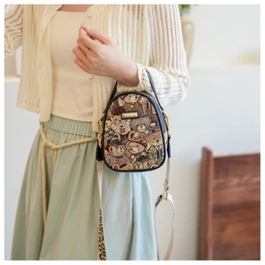 Detail of a small dome crossbody bag with teddy bear print and navy leather trim
