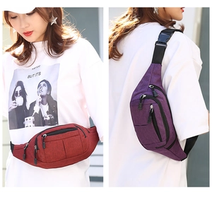 Detail of burgundy and purple nylon waist bags with multi-layer zipper pockets for travel