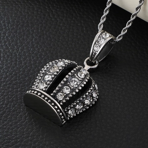 Macro shot of silver crown pendant with sparkling rhinestones on black leather surface