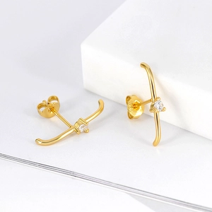 Macro shot of gold-plated S925 silver cross earrings with sparkling white zircon stones