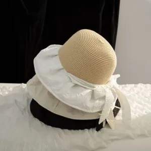 Détail de chapeaux en paille avec broderie florale et rubans élégants sur le côté