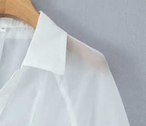 Close-up of white V-neck dress shirt collar with S size tag and sheer fabric texture