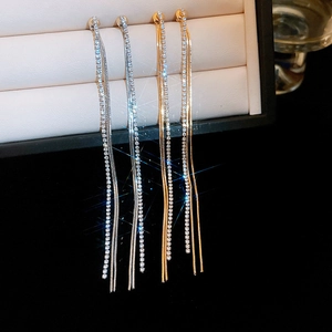 Detail view of long tassel earrings with sparkling rhinestones in gold and silver finishes