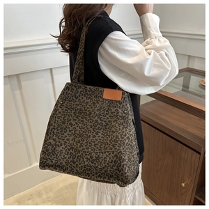 Detail of leopard print tote bag with brown leather patch and metal rivet decoration