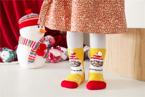 Cozy coral fleece Christmas socks shown in a warm holiday scene with festive decor