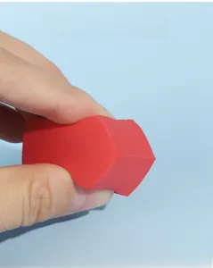 Macro shot of resilient red makeup sponge showing high elasticity and soft texture