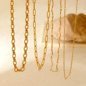 Detailed view of four assorted golden stainless steel chain necklaces in varied textures