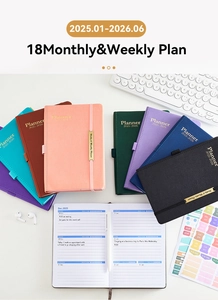 Flat lay of colorful 18-month faux leather planners with open page layout on a white desk